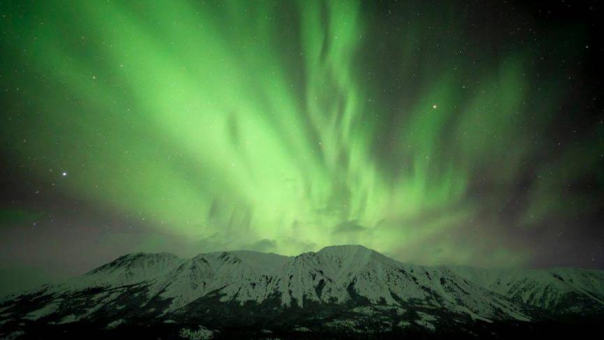 Green aurora over mountain